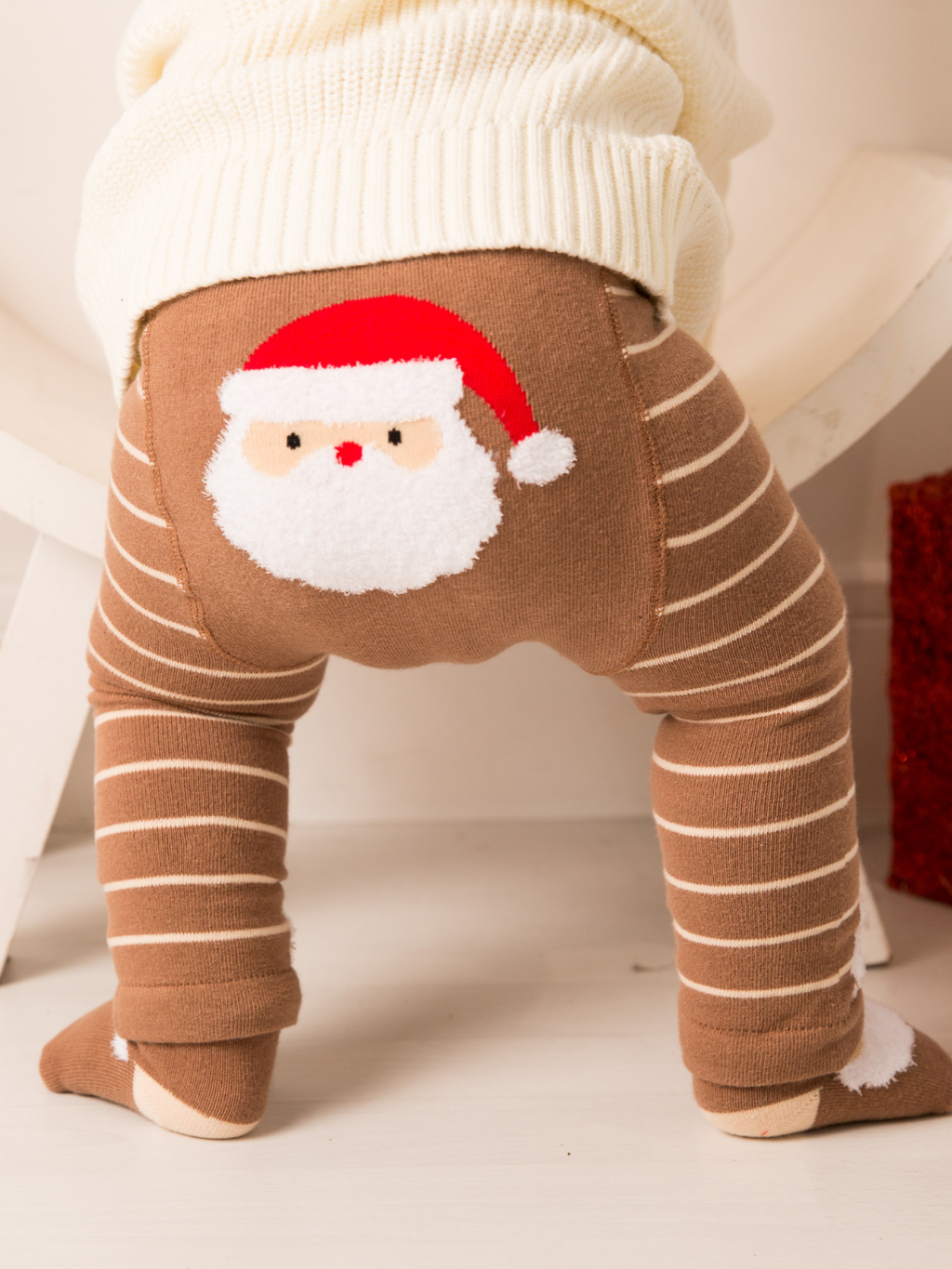 Santa Ho Ho Ho Leggings worn by a baby, showing the fluffy Santa on the seat panel above brown and cream stripes