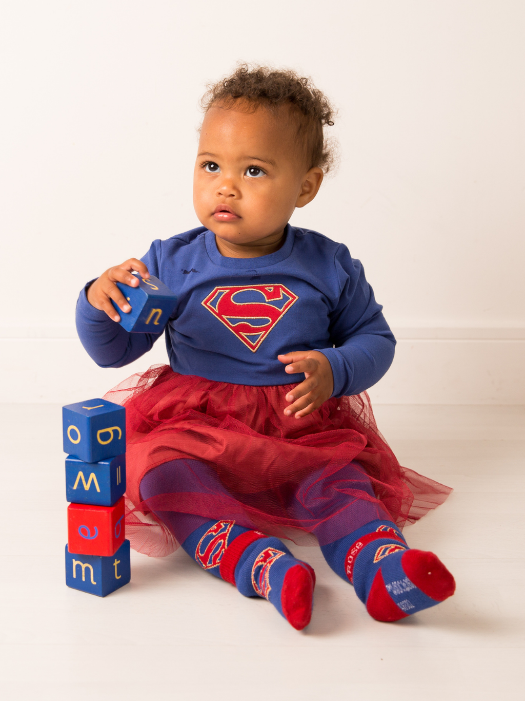Baby wearing the Supergirl™ Unstoppable dress and matching leggings